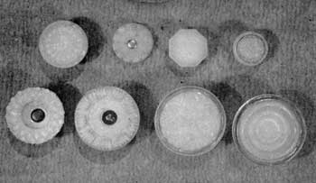 Eight Knobs of Opalescent Glass: Five of the designs shown are known Sandwich patterns. The others, because tint and fire of glass is identical, probably also came from there. Top row, left to right: Medium size with daisy design; button to be set in brass cup; six-sided flat knob for brass base (both from Sandwich); and very small floral knob. Lower row, left to right: Small diamond pattern; a popular conventional design; floral rosette also used for Sandwich tiebacks; and a circular design copied from brass knobs of the period.